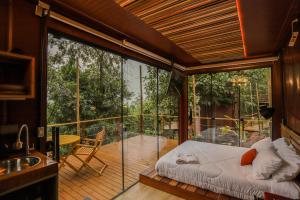 a room with a bed on a balcony at João de Barro - Deck Tiny House in Mairiporã