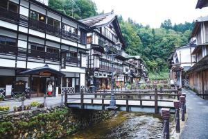 a group of buildings next to a river in a town at 甘口派room in Obanazawa