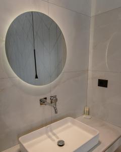 a white bathroom with a sink and a mirror at Nireus Hotel in Symi