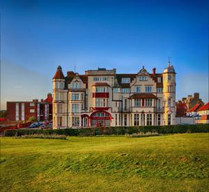 un gran edificio con un campo de césped delante de él en Cliftonville Hotel, en Cromer