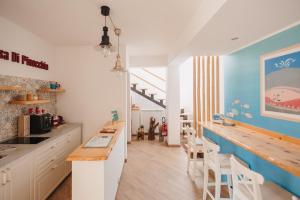 a kitchen with white cabinets and a blue wall at La Casa Di Pinocchio in Enna