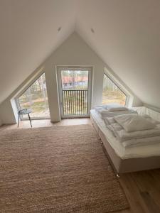 a bedroom with a bed and two large windows at Modern Mountain Cabin in Idre 1022 in Idre