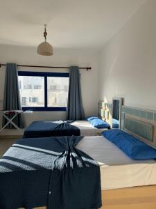 zwei Betten in einem Schlafzimmer mit Fenster in der Unterkunft Marassi in Dawwār Abū Maḩrūs