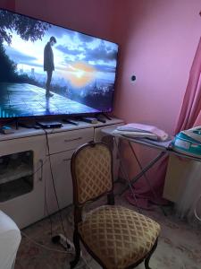 a room with a tv and a chair and a table at Otthon in Budaörs