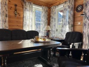 a dining room with a table and chairs and windows at Cozy cabin in Eikedalen in Eikjedalen