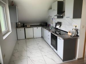 a kitchen with white cabinets and a tile floor at Eros & Aphrodite in Samobor