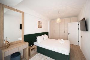 Un dormitorio pequeño con una cama y un espejo. en Dream luxury apartments in Infinity pool Spa resort, en Mamaia