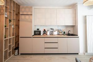 cocina con armarios blancos y encimera en Dream luxury apartments in Infinity pool Spa resort, en Mamaia