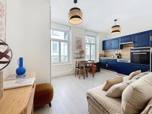 een woonkamer met een bank en een keuken bij Le Mourillon - Centre Ville in Wimereux