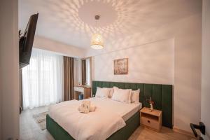 Un dormitorio con una cama grande con cabecero verde. en Dream luxury apartments in Infinity pool Spa resort, en Mamaia