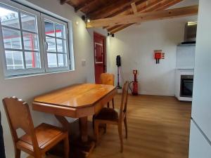 a dining room with a wooden table and chairs at Quinta do Atlântico in Biscoitos