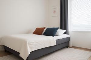 a bedroom with a bed with white sheets and a window at Tammer Huoneistot - City Suite 6 - Best Location & Great Amenities in Tampere +10 photos