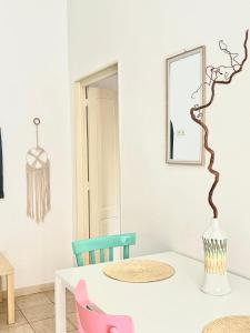a dining room with a white table and pink chairs at Casa Myda in Bari