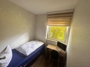 a small bedroom with a bed and a window at Bach's Restaurant Bar Hotel in Erkrath