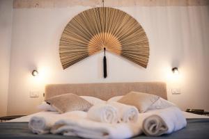 a clock on a wall above a bed with towels at Domus Villanova in Triggianello