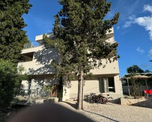 un edificio con bicicletas estacionadas frente a un árbol en Supetar Cypress House, en Supetar