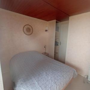 a bedroom with a bed and a clock on the wall at Chalet Lestraouen in Plougastel-Daoulas