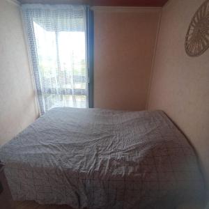 a bedroom with a bed and a window at Chalet Lestraouen in Plougastel-Daoulas