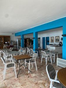 a restaurant with tables and chairs and a blue wall at Hotel Restaurant Le Filosorma in Galeria