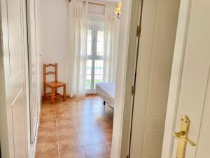 a hallway with a door to a room with a chair at Atlántico, Playa Punta del Moral - By AC REAL in Punta del moral +30 photos