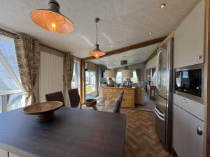 Il dispose d'une cuisine et d'un salon avec une table et un réfrigérateur. dans l'établissement Stewarts Resort Lodge 59, à St Andrews