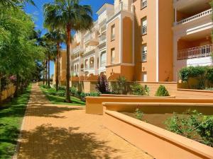 a street in front of a building with palm trees at Atlántico, Playa Punta del Moral - By AC REAL in Punta del moral