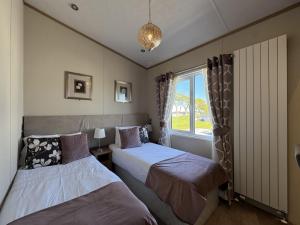 une chambre avec deux lits et une fenêtre dans l'établissement Stewarts Resort Lodge 59, à St Andrews