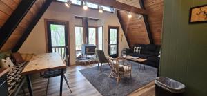 a living room with a couch and a table at Golden A Frame- 3 bedroom with hot tub and community amenities in Swanton