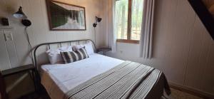 a bedroom with a bed and a window at Golden A Frame- 3 bedroom with hot tub and community amenities in Swanton