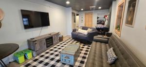a living room with a couch and a tv on a wall at Golden A Frame- 3 bedroom with hot tub and community amenities in Swanton