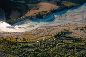an aerial view of a river and forests at Chalten Camp - Glamping with a view in El Chalten
