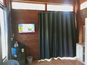 a green curtain in a room with a window at เขาแคบ วิลล่า in Pak Chong