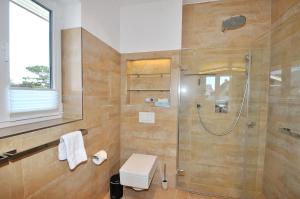 a bathroom with a shower and a toilet and a sink at Appartement Penthouse in St. Peter-Ording +10 photos