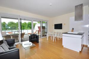a living room with a couch and a kitchen and a table at Appartement Penthouse in St. Peter-Ording