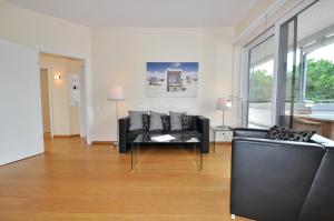 a living room with a black couch and chairs at Appartement Penthouse in St. Peter-Ording