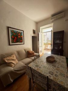 阿尔盖罗Flowered House with garden的客厅里有一张沙发和一张桌子。