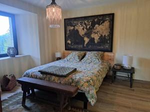 a bedroom with a bed with a map on the wall at La Clef des songes in Lafarre