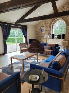 un soggiorno con un divano blu e un tavolo di Maison du parc - Château de Musigny a Musigny