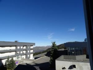 une vue d'un bâtiment avec des montagnes en arrière-plan dans l'établissement Studio cosy 4 pers, ski aux pieds, casier à skis, parkings gratuits, équipement complet inclus. - FR-1-602-4, à Arette