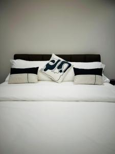 a white bed with black and white pillows on it at The address, Colombo in Colombo