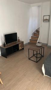 ChaulgnesにあるMaison cosy près du circuit Nevers Magny-Coursのリビングルーム(テレビ、テーブル付)、階段