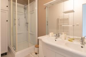 a white bathroom with a sink and a shower at Maison aux Moutiers - Wifi - Terrasse in Prigny +9 photos