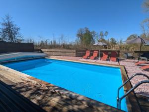 a swimming pool with two chairs and a table at La fermette du Marais in Rue