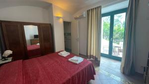 a bedroom with a red bed and a large window at L'Angolo 7 in Atrani