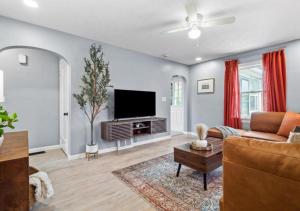 a living room with a couch and a flat screen tv at Expertly Designed Lake Erie Escape with Hot Tub in Lorain