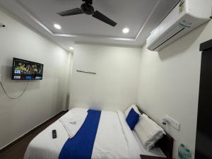 una camera con letto e ventilatore a soffitto di COCO NET Hotel a Ibrāhīmpatan