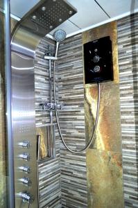 a shower with a shower head in a bathroom at Double room in riverside apartment - B in Glasgow +15 photos