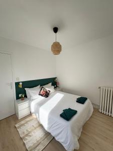a bedroom with a large white bed with a green headboard at Maison moderne en plein centre ville du Havre avec jacuzzi et parking gratuit in Le Havre