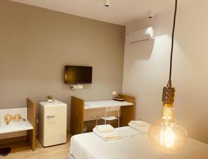 a room with a bed and a desk and a tv at SARANDA Vila HM in Sarandë