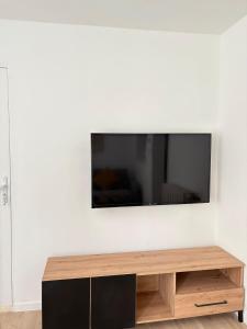 a flat screen tv on a white wall at Maison moderne en plein centre ville du Havre avec jacuzzi et parking gratuit in Le Havre